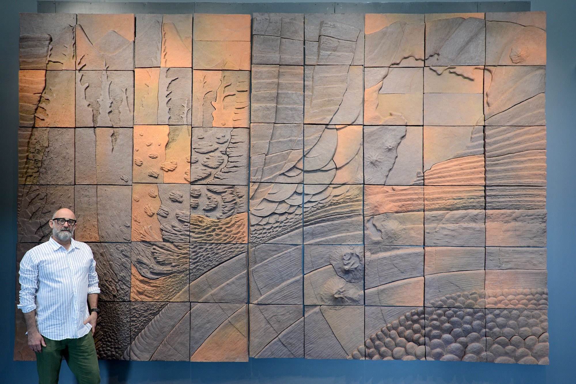 Taupō local Chris Johnston standing in front of artwork by renowned Kiwi artist Barry Brickell.